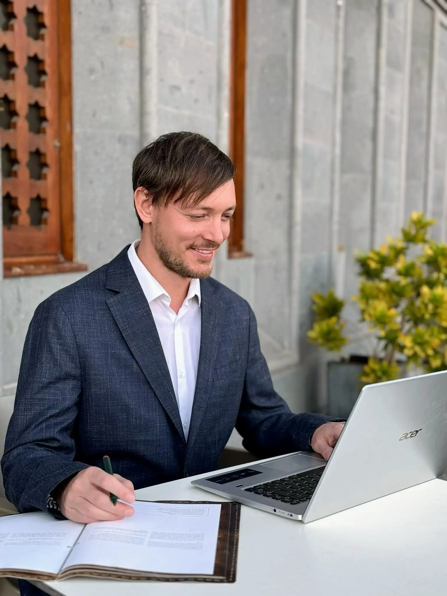 Markus Garth, ein engagierter Lehrer und Coach, sitzt im Freien an einem Tisch, arbeitet mit Laptop und Notizen und begleitet Teilnehmer auf ihrem Weg zum Erfolg.